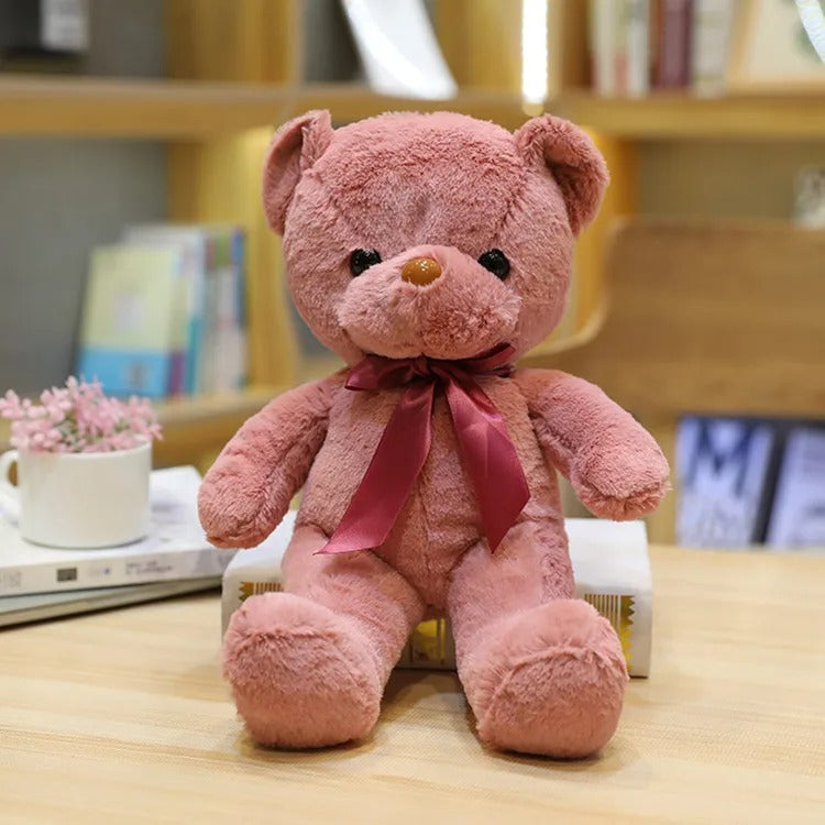 Un adorable ours en peluche rose avec un nĆud en satin marron.