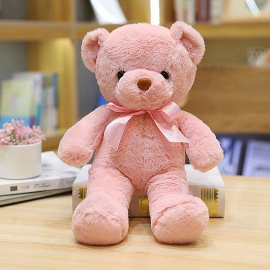 Un adorable ours en peluche rose avec un nĆud en satin.