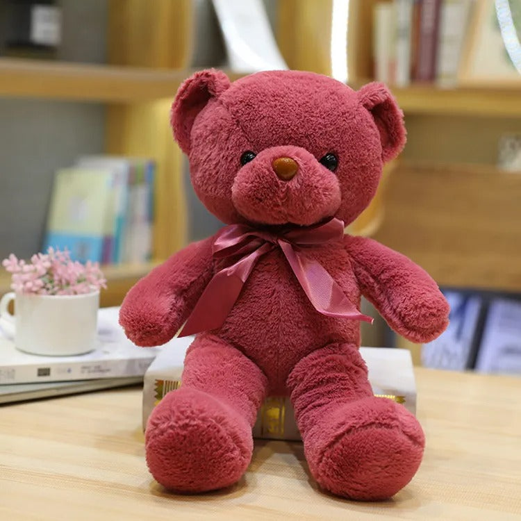 Charmant Ours en peluche rouge assis, avec un joli ruban.