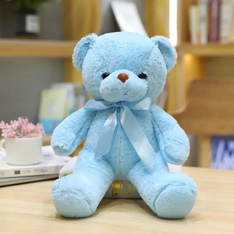 Adorable, doux Ours en peluche bleu avec nĆud satinĂ©, assis, intĂ©rieur.