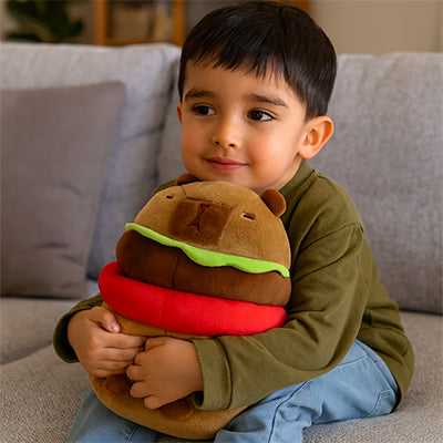 Adorable enfant cùlinant une peluche capybara en forme de burger sur canapé.