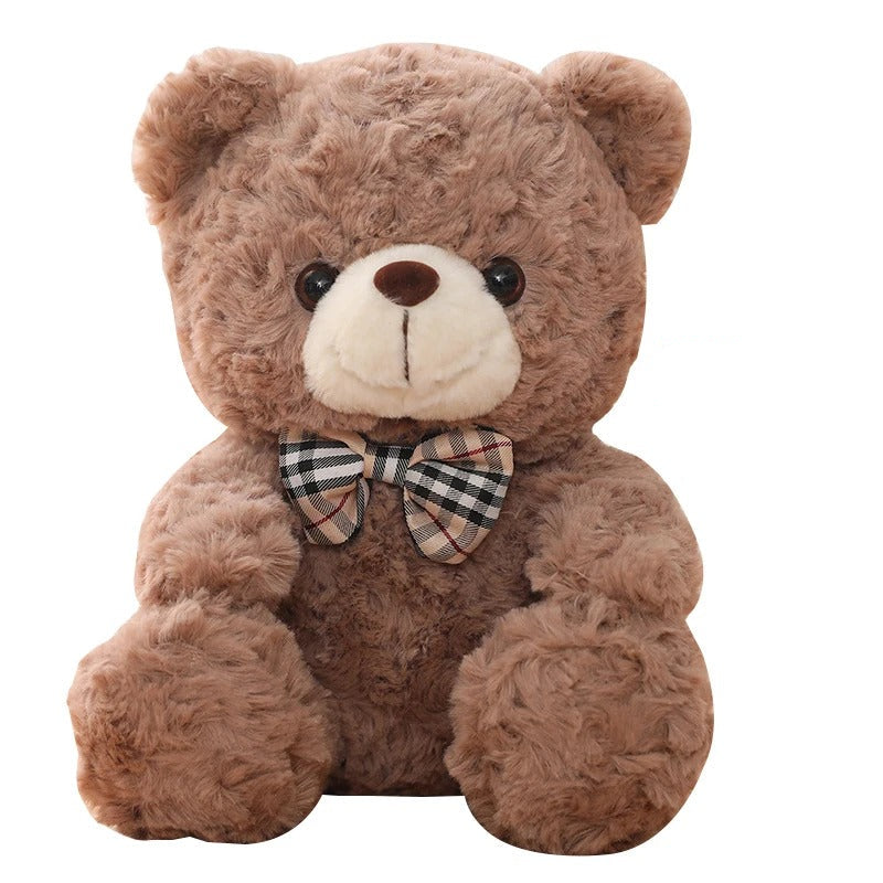 Adorable ours en peluche brun avec un nĆud papillon Ă carreaux, mesurant 25cm.