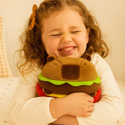 Fillette joyeuse étreignant sa peluche capybara "burger" adorée.