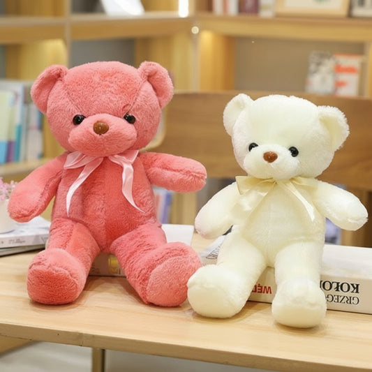 Deux ours en peluche, un rose et un crème, assis sur une table.