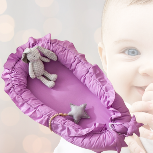 Un doux cocon violet invite au repos, paré d'un adorable lapin à carreaux et d'une étoile grise.
Ce nid douillet semble attendre l'arrivée de bébé, promettant confort et sécurité.
En arrière-plan, le visage flou d'un nourrisson évoque la tendresse de l'enfance.
Une atmosphère paisible et chaleureuse se dégage de cette scène délicate
