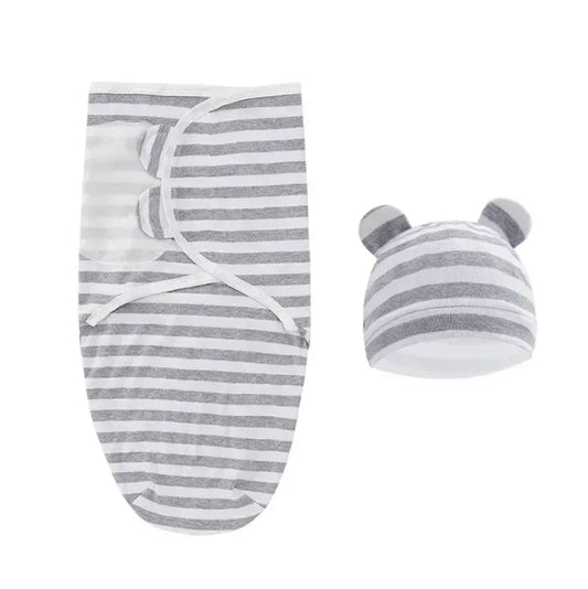 La Couverture emmaillotage bébé| Douce Câline™ est un lange rayé gris et blanc avec un bonnet à oreilles d'ours assorti, présenté sur fond blanc, idéal pour apaiser le réflexe de Moro et assurer un sommeil paisible.