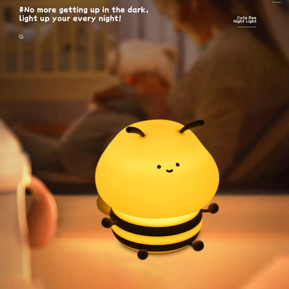 La veilleuse Veilleuse bébé | Abeille™, en forme d'abeille, éclaire chaleureusement une table à côté d'un enfant dans un lit. Le texte dit : « Ne vous levez plus dans le noir ; illuminez vos nuits sereines !.