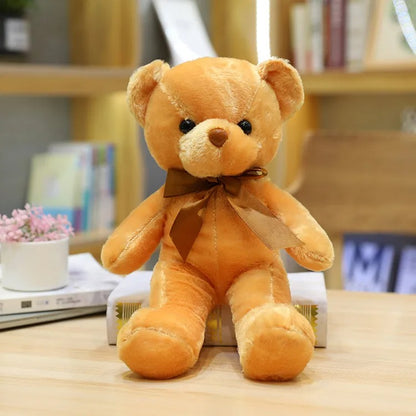 Adorable ours en peluche brun clair avec un nœud marron assis.