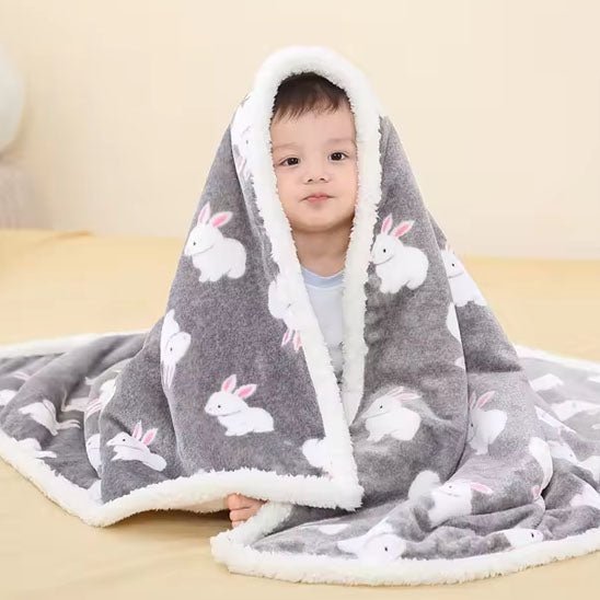 Bébé enveloppé dans une couverture douce à motifs de lapins mignons.