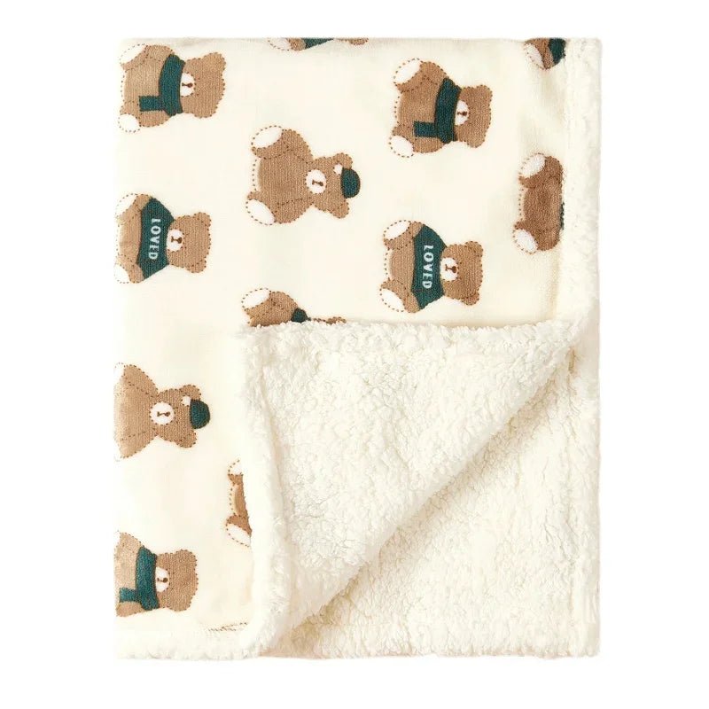 Bébé souriant enveloppé dans une couverture douce à motifs d'oursons.